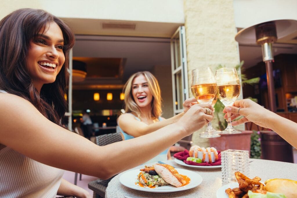 A group of women enjoying a toast on the patio of Tempe Mission Palms Hotel