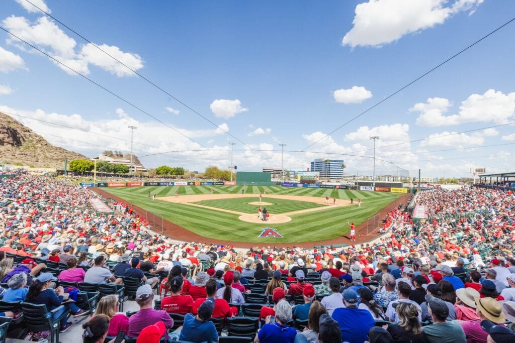 Crowd watching a baseball game at Tempe Diablo Stadium on a sunny day in Tempe, AZ.